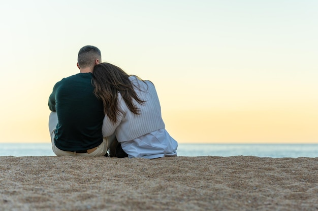 Casal apaixonado muito juntinho na areia da praia