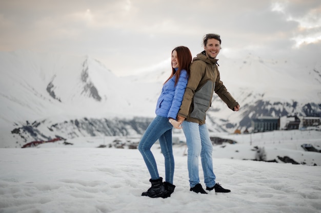 Casal apaixonado no inverno se divertindo nas montanhas