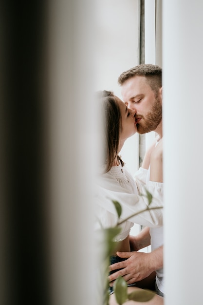 Casal apaixonado no quarto. Morena esbelta. Interior elegante.