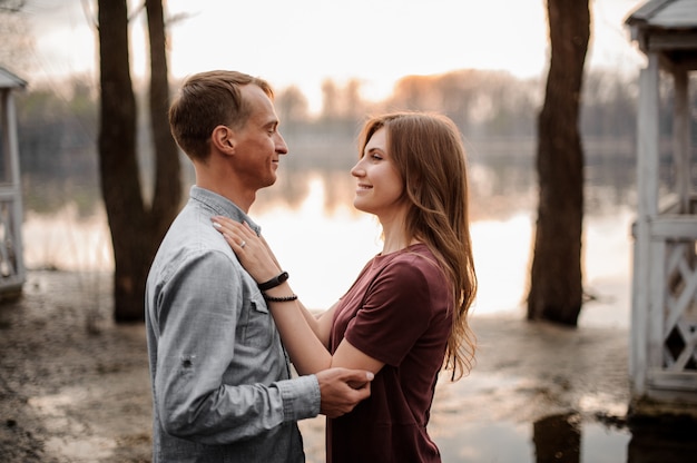 Casal apaixonado, olhando os olhos na cena do belo lago