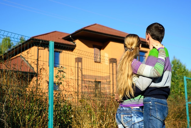 Casal apaixonado olhando para o espaço de cópia da casa dos seus sonhos