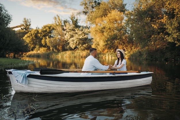 Casal apaixonado passeando de barco no lago, encontro romântico