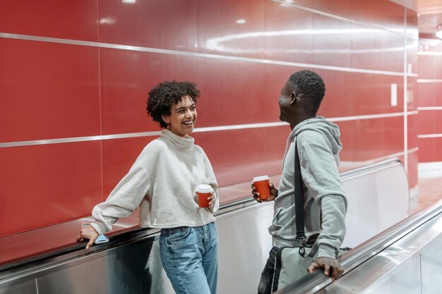 Casal apaixonado por um café para viagem está flertando no metrô