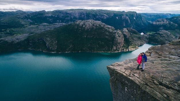 Foto casal apaixonado preikestolen enorme penhasco (noruega, lysefjorden, manhã, manhã, vista)