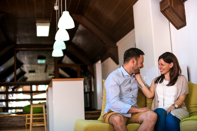 Casal apaixonado relaxando no sofá em casa