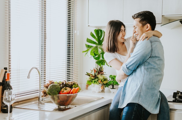 Casal apaixonado rindo e se divertindo juntos na cozinha