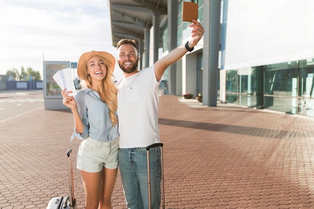 Foto casal apaixonado saindo de férias e segurando ingressos