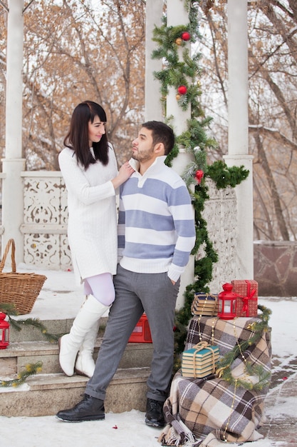 Casal apaixonado se abraçando em um gazebo decorado de natal