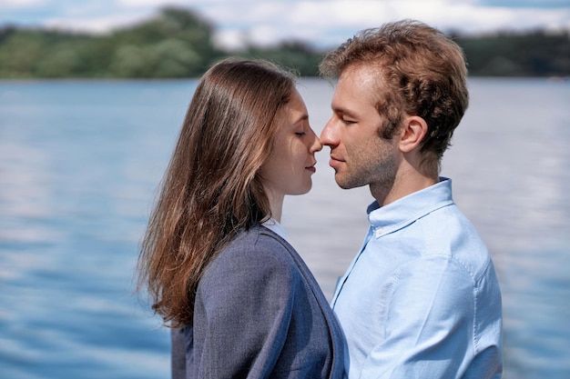 Casal apaixonado se beijando em pé na margem do lago