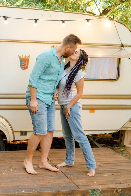 Casal apaixonado se beijando perto do trailer