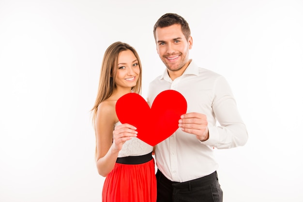 Casal apaixonado segurando um grande coração de papel