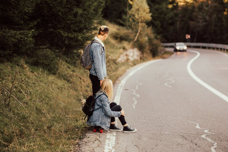 Foto casal apaixonado, sentado na beira da estrada e olhando para a máquina que vai para uma reunião.