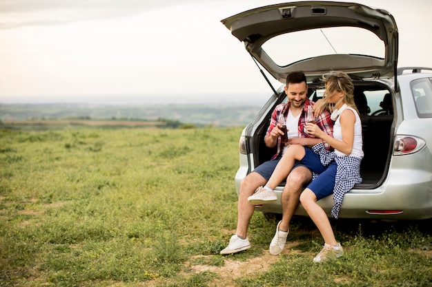 Foto casal apaixonado sentado no trank do carro