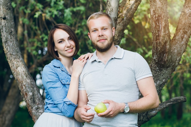 Casal apaixonado tem um descanso no pomar de verão