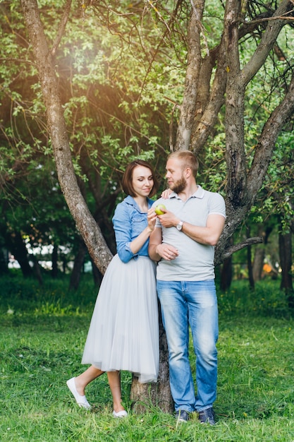 Casal apaixonado tem um descanso no pomar de verão