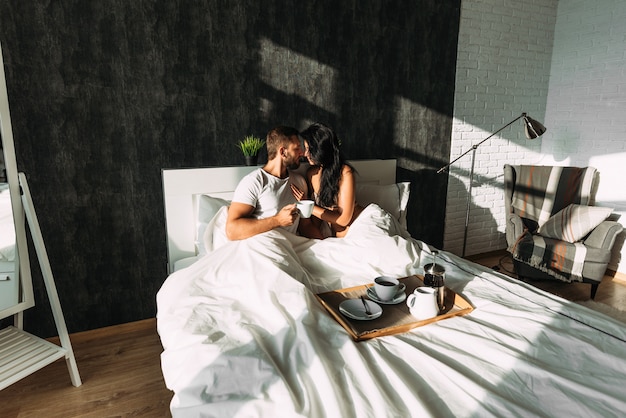 Casal apaixonado tomando café da manhã na cama