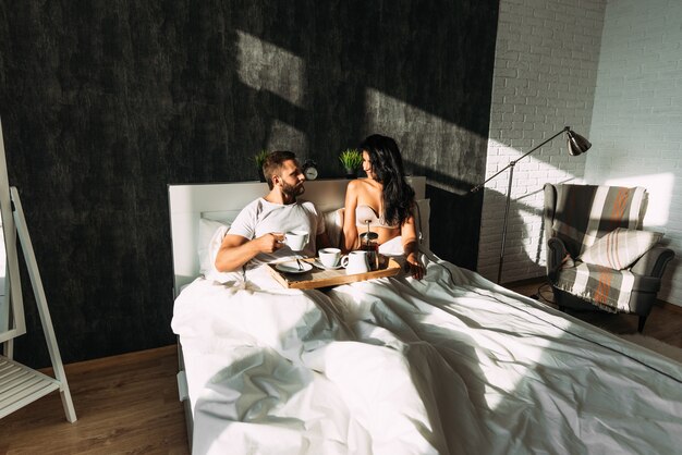 Casal apaixonado tomando café da manhã na cama