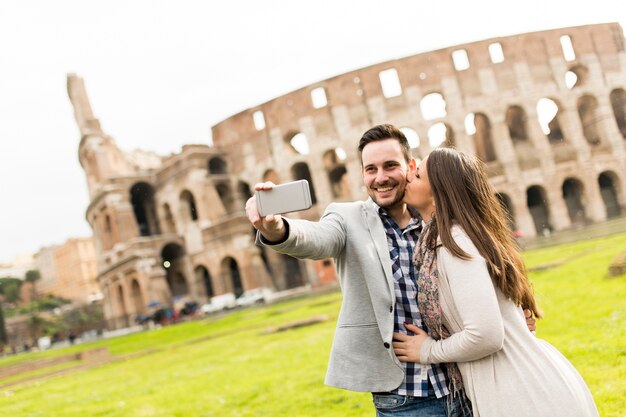 Casal apaixonado tomando selfie na frente do Coliseu