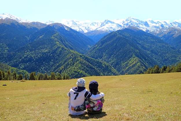 Casal aprecia a vista incrível da montanha do cáucaso coberta de neve do highland em mestia, geórgia