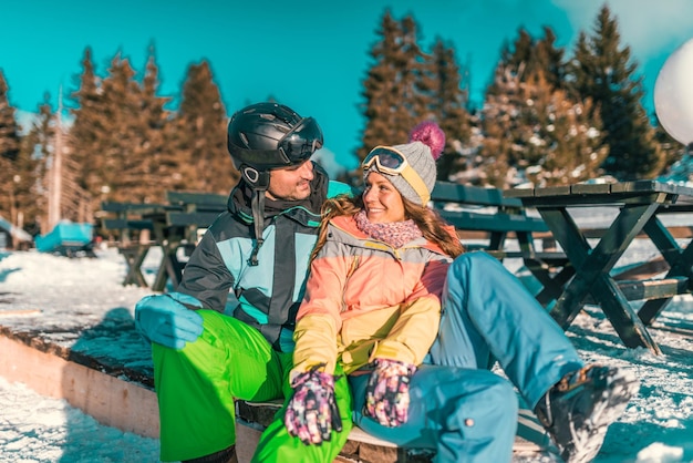 Casal aproveitando o dia de inverno na montanha