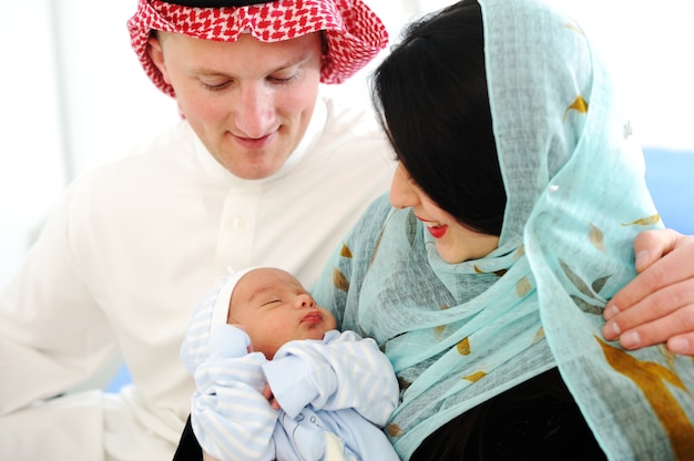 Casal árabe muçulmano com novo bebê em casa