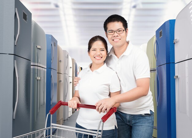 Casal asiático comprando refrigerador em loja de compras