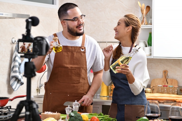 Casal asiático gravando um vídeo na cozinha