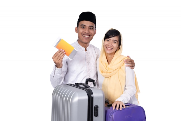 Casal asiático muçulmano com mala de viagem