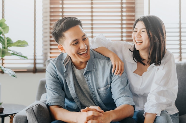 Casal asiático se divertindo e rindo no quarto amoroso