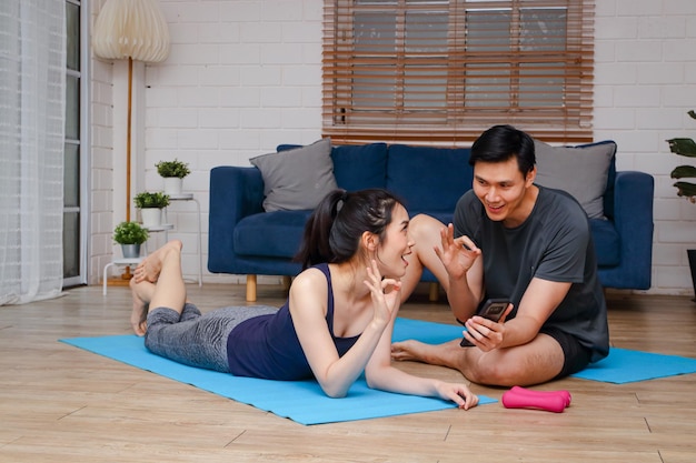 Casal asiático se exercitando juntos em casa na sala de estar Exercício de conceito esportivo para uma boa saúde