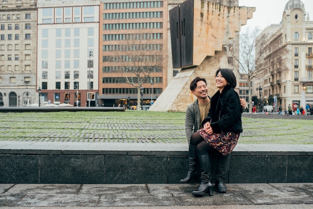 Casal asiático turista feliz sentado no colo