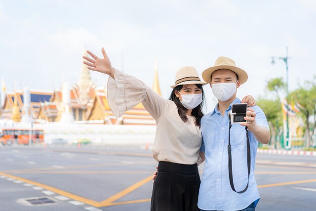 Casal asiático turista usando uma máscara protetora