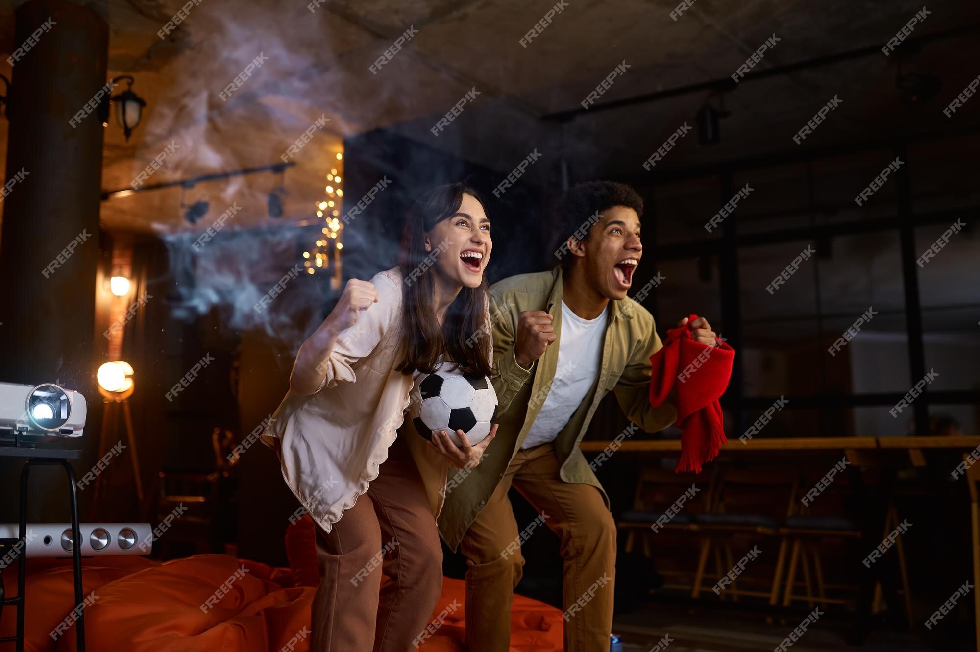 Casal Jovem, Mulher Homem, Fãs De Futebol Animam A Equipe De Apoio,  Assistindo Ao Jogo No Laptop Do PC, Segurando A Bola De Futebol, Cartão De  Crédito Isolado No Fundo Branco. Conceito