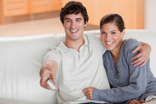 Casal assistindo televisão no sofá