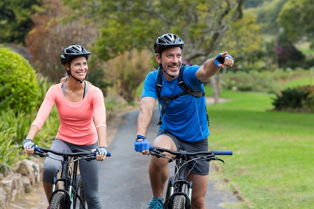 Casal Atlético apontando enquanto andava de bicicleta