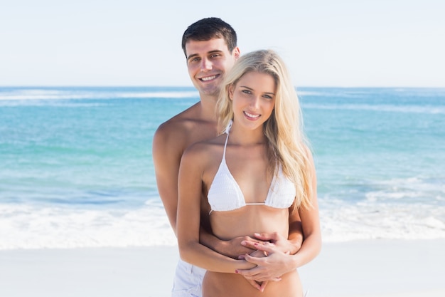 Casal atraente abraçando e sorrindo para a câmera