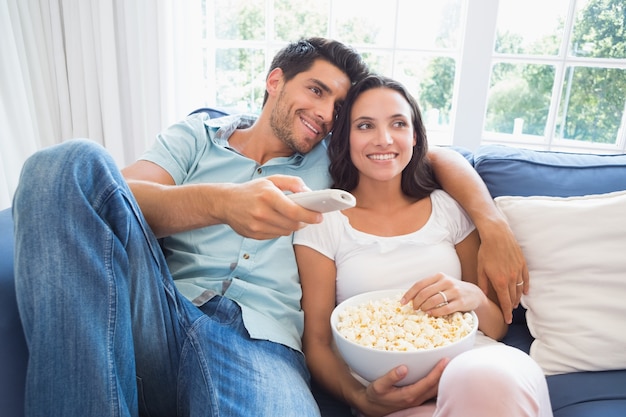 Casal atraente assistindo tv no sofá