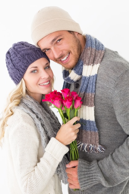Casal atraente em roupas quentes segurando flores