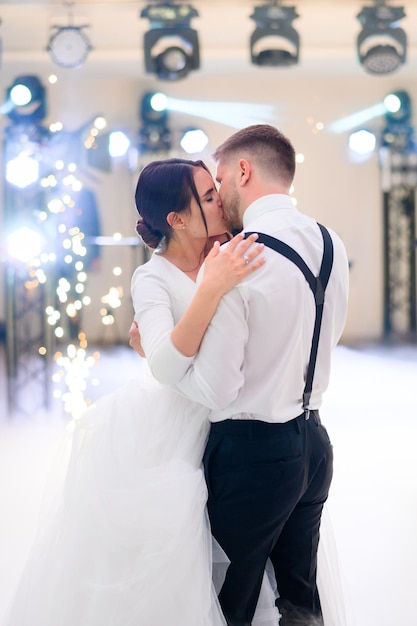 Casal atraente noiva e noivo beijando enquanto dançava no dia do casamento Linda mulher de vestido longo branco com homem amoroso comemorando o dia da criação de uma família