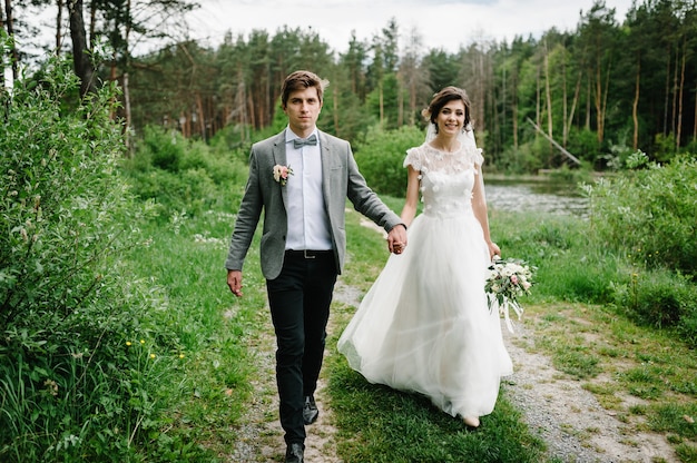 Casal atraente recém-casados na pista no jardim