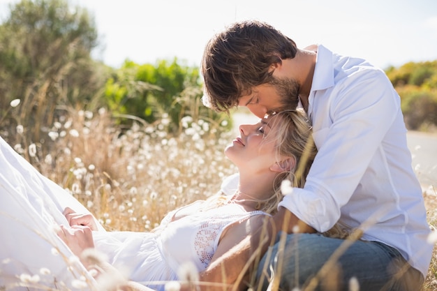 Casal atraente relaxando no campo