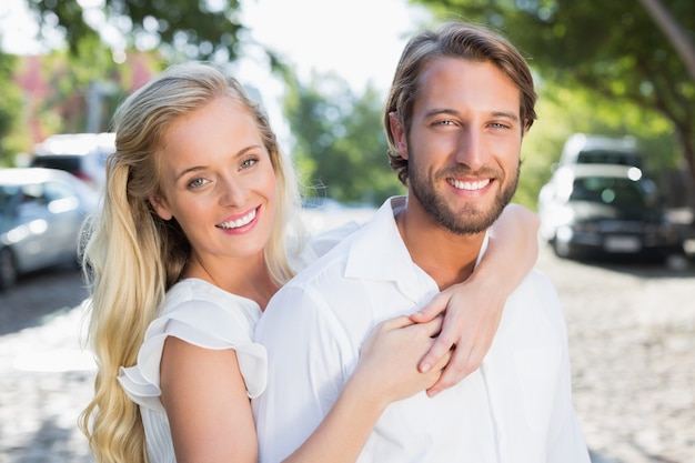 Casal atraente se abraçando e sorrindo para a câmera