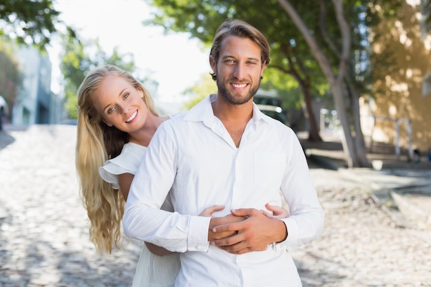 Casal atraente se abraçando e sorrindo para a câmera