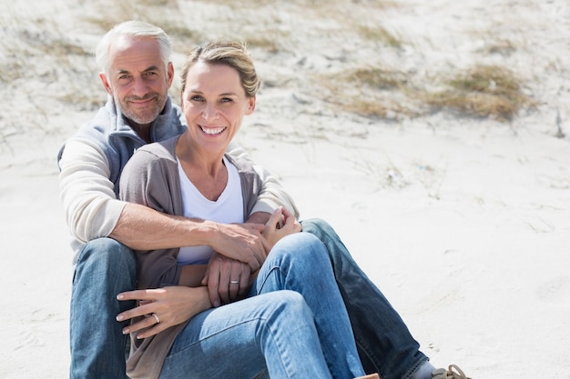 Casal atraente sorrindo um para o outro na praia