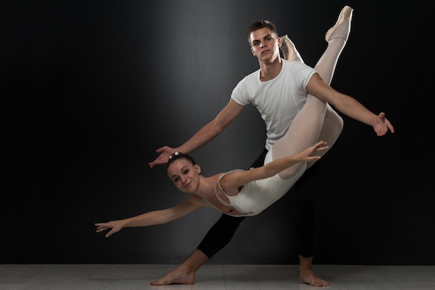 Casal bailarina dançarina de balé dançando em fundo preto