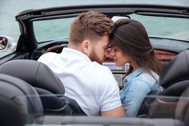 Casal beijando no cabriolet branco ao ar livre