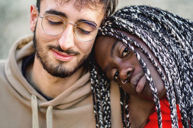 Foto casal biracial afetuoso sentado ao ar livre - close-up tiro