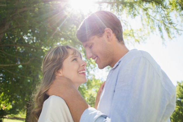 Casal bonito abraçando e sorrindo no parque