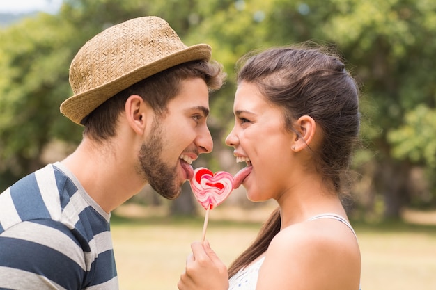 Casal bonito compartilhando um pirulito