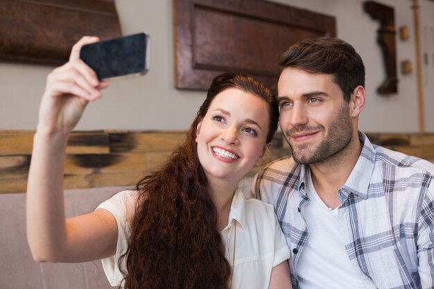 Casal bonito em um encontro que toma um selfie